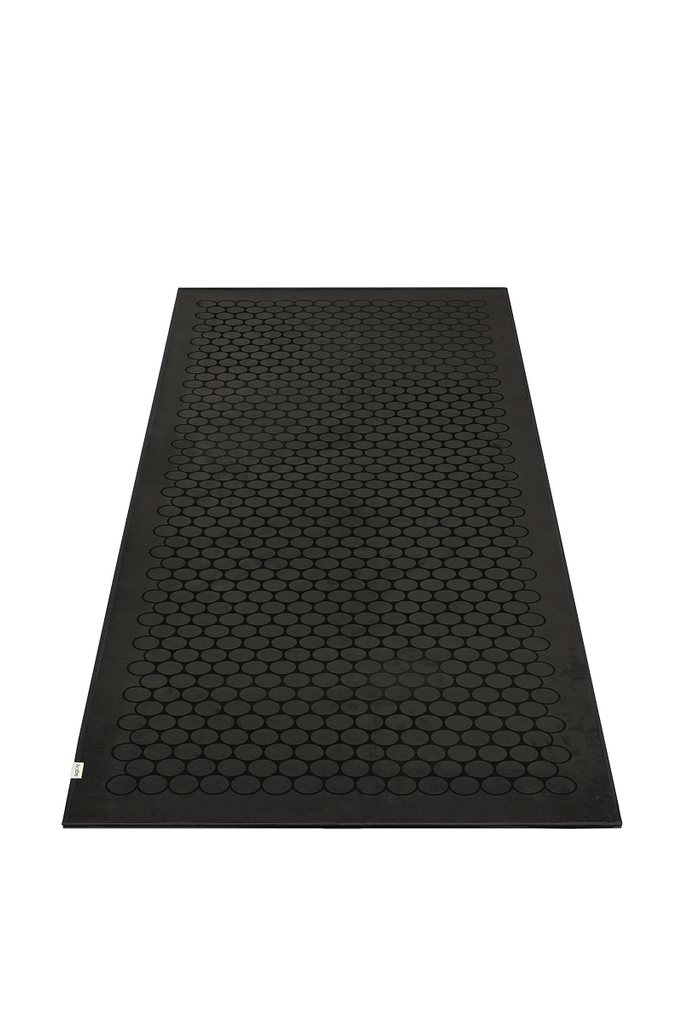 The GECKO TOUCH – Nightfall yoga towel features a simple yet elegant symmetrical circular pattern made of tactile silicone, offering a unique wet/dry grip. It comes with a sleek black graphite base with contrasting colored stitching and is made using an eco-friendly, dye-free process.