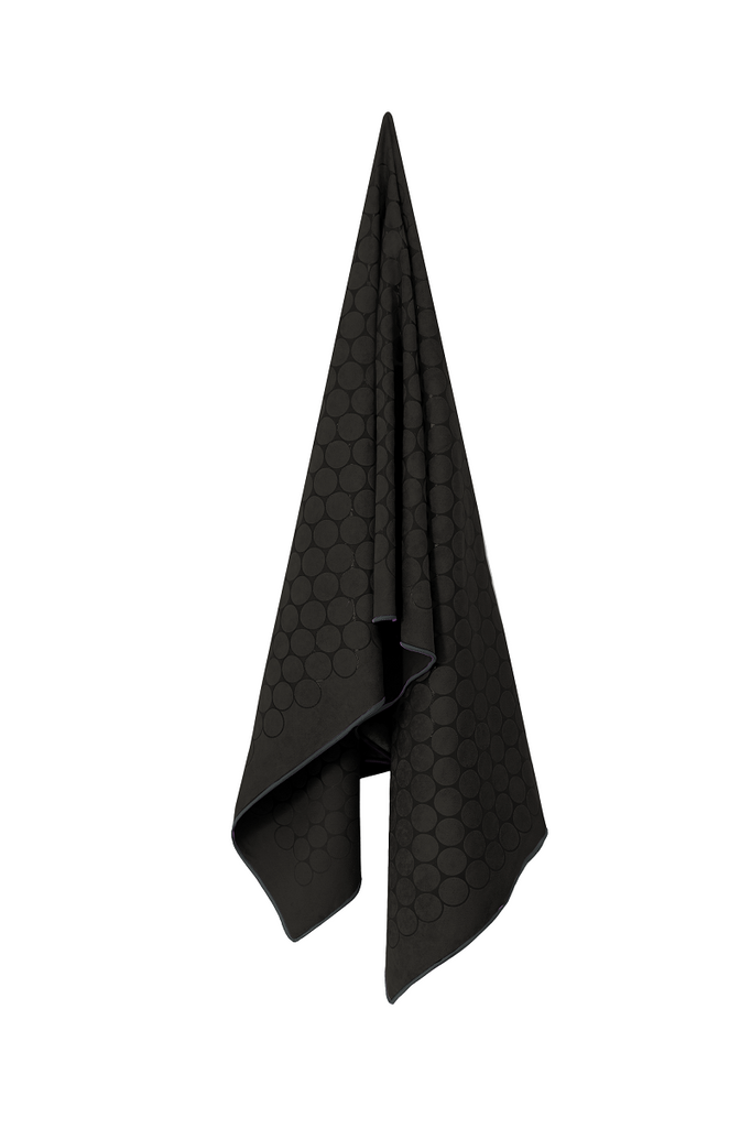 The GECKO TOUCH – Nightfall yoga towel features a simple yet elegant symmetrical circular pattern made of tactile silicone, offering a unique wet/dry grip. It comes with a sleek black graphite base with contrasting colored stitching and is made using an eco-friendly, dye-free process.
