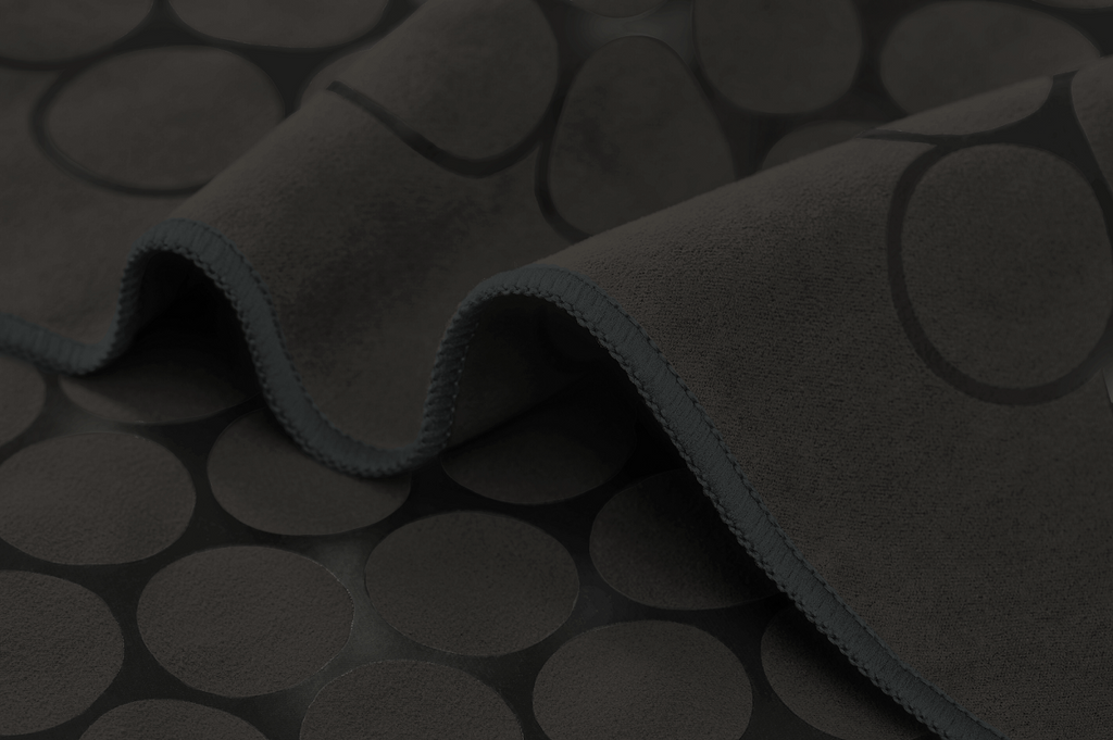 The GECKO TOUCH – Nightfall yoga towel features a simple yet elegant symmetrical circular pattern made of tactile silicone, offering a unique wet/dry grip. It comes with a sleek black graphite base with contrasting colored stitching and is made using an eco-friendly, dye-free process.