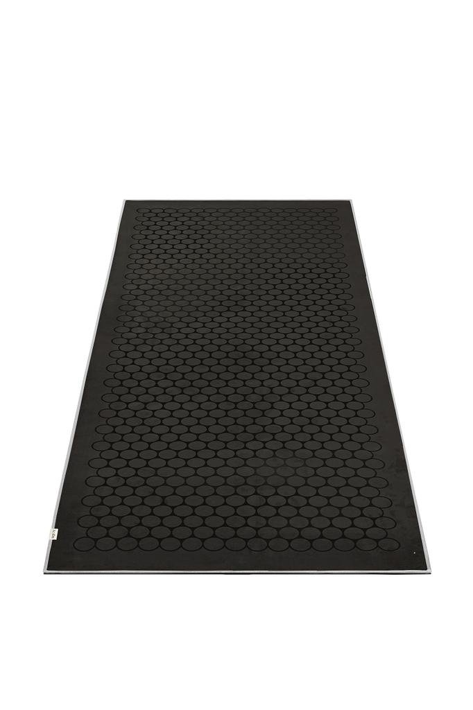 The GECKO TOUCH – Nightfall yoga towel features a simple yet elegant symmetrical circular pattern made of tactile silicone, offering a unique wet/dry grip. It comes with a sleek black graphite base with contrasting colored stitching and is made using an eco-friendly, dye-free process.