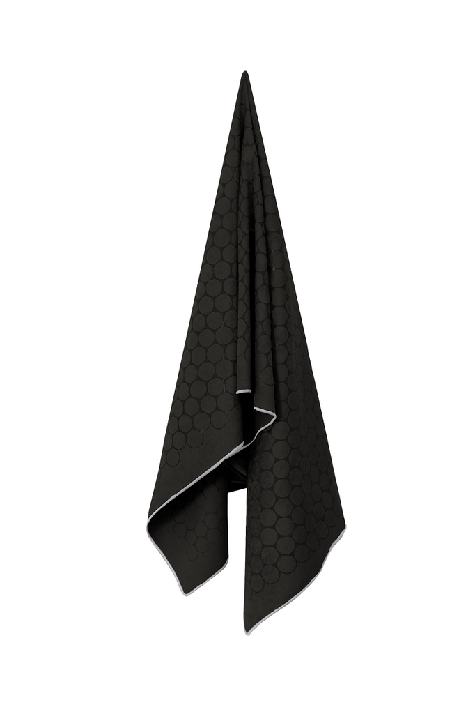 The GECKO TOUCH – Nightfall yoga towel features a simple yet elegant symmetrical circular pattern made of tactile silicone, offering a unique wet/dry grip. It comes with a sleek black graphite base with contrasting colored stitching and is made using an eco-friendly, dye-free process.