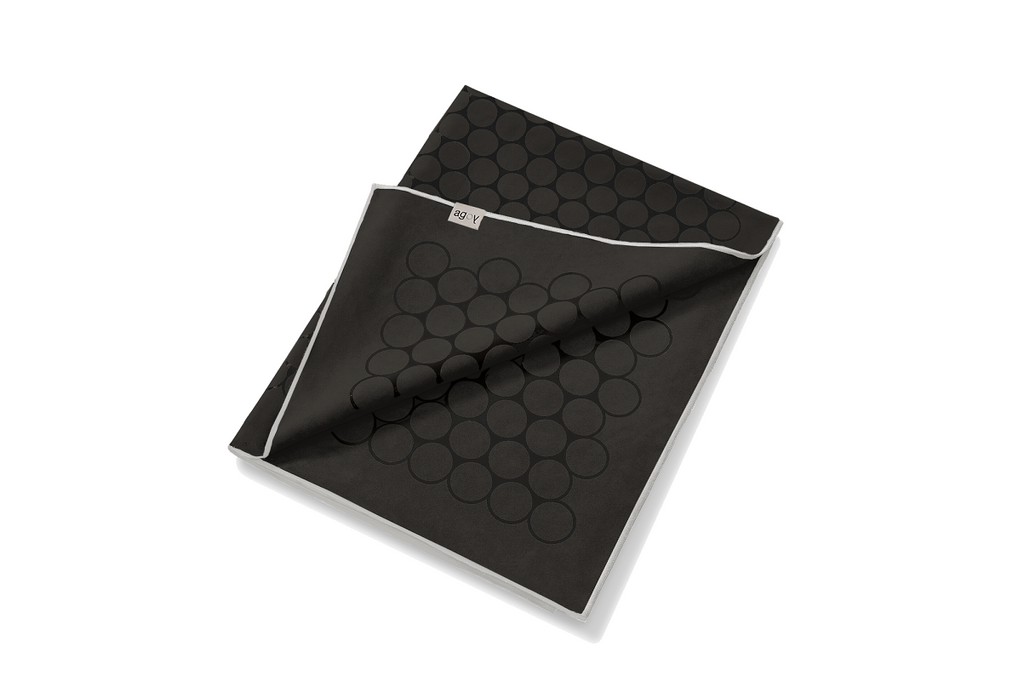 The GECKO TOUCH – Nightfall yoga towel features a simple yet elegant symmetrical circular pattern made of tactile silicone, offering a unique wet/dry grip. It comes with a sleek black graphite base with contrasting colored stitching and is made using an eco-friendly, dye-free process.