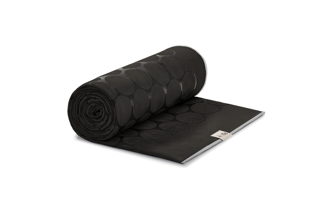 The GECKO TOUCH – Nightfall yoga towel features a simple yet elegant symmetrical circular pattern made of tactile silicone, offering a unique wet/dry grip. It comes with a sleek black graphite base with contrasting colored stitching and is made using an eco-friendly, dye-free process.