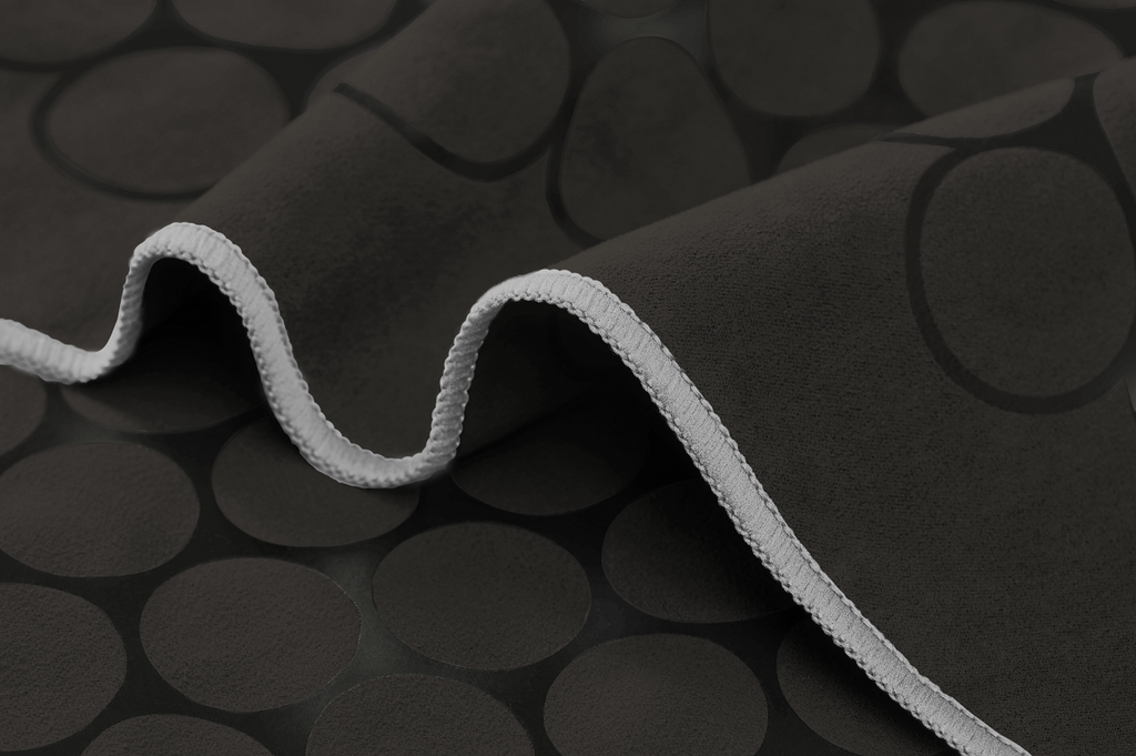 The GECKO TOUCH – Nightfall yoga towel features a simple yet elegant symmetrical circular pattern made of tactile silicone, offering a unique wet/dry grip. It comes with a sleek black graphite base with contrasting colored stitching and is made using an eco-friendly, dye-free process.