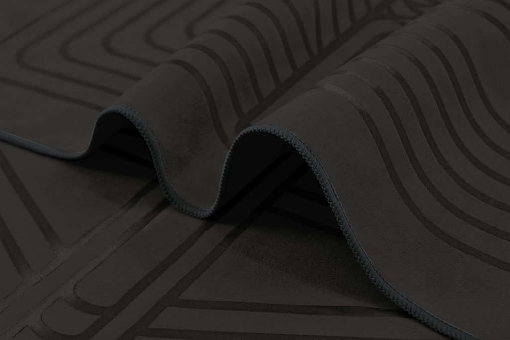 The GECKO WARRIOR – Nightfall yoga towel features a unique wet/dry grip Focus Alinement™ pattern made of tactile silicone, inspired by but not directly taken from ancient warrior cultures. It comes with a sleek black graphite base with contrasting colored stitching and is made using an eco-friendly, dye-free process.