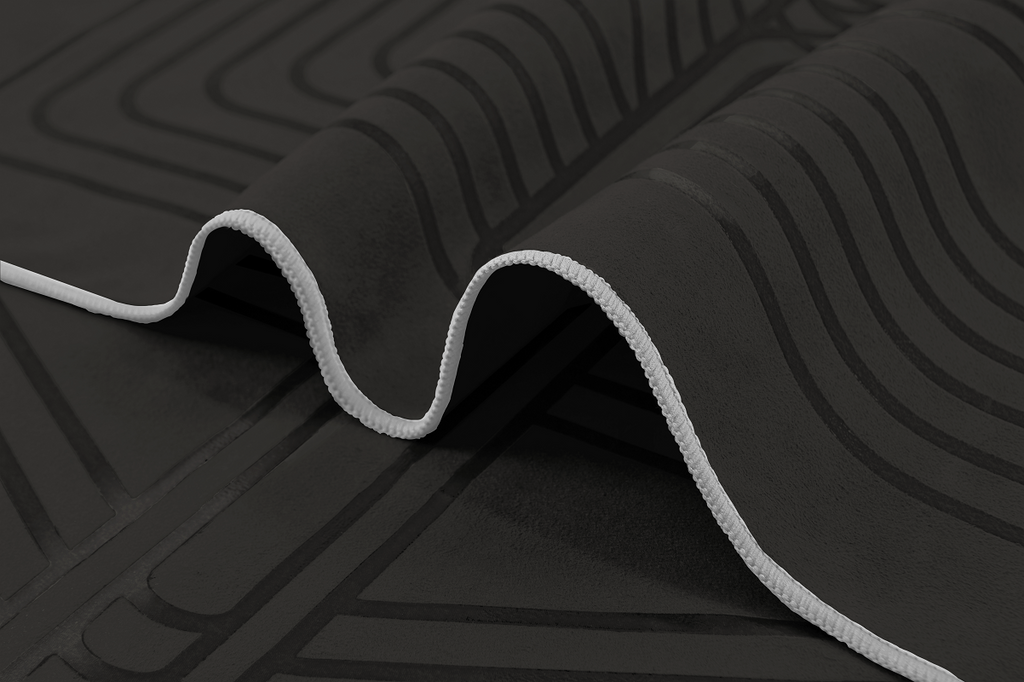 The GECKO WARRIOR – Nightfall yoga towel features a unique wet/dry grip Focus Alinement™ pattern made of tactile silicone, inspired by but not directly taken from ancient warrior cultures. It comes with a sleek black graphite base with contrasting colored stitching and is made using an eco-friendly, dye-free process.