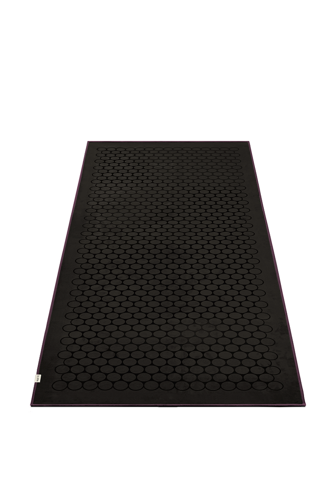 The GECKO TOUCH – Nightfall yoga towel features a simple yet elegant symmetrical circular pattern made of tactile silicone, offering a unique wet/dry grip. It comes with a sleek black graphite base with contrasting colored stitching and is made using an eco-friendly, dye-free process.