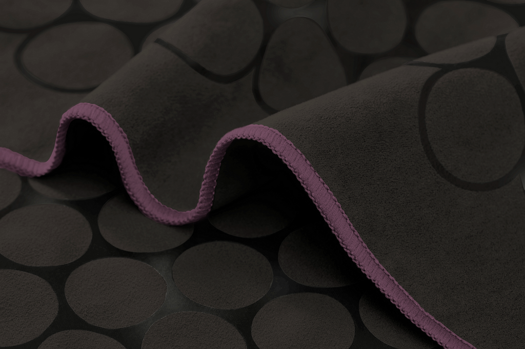The GECKO TOUCH – Nightfall yoga towel features a simple yet elegant symmetrical circular pattern made of tactile silicone, offering a unique wet/dry grip. It comes with a sleek black graphite base with contrasting colored stitching and is made using an eco-friendly, dye-free process.