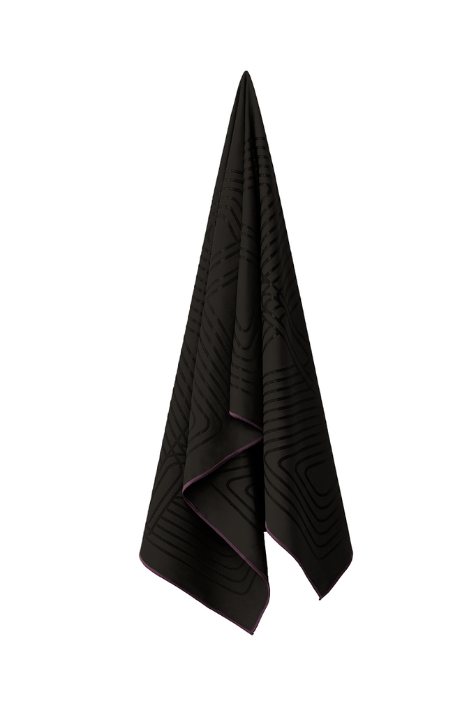 The GECKO WARRIOR – Nightfall yoga towel features a unique wet/dry grip Focus Alinement™ pattern made of tactile silicone, inspired by but not directly taken from ancient warrior cultures. It comes with a sleek black graphite base with contrasting colored stitching and is made using an eco-friendly, dye-free process.