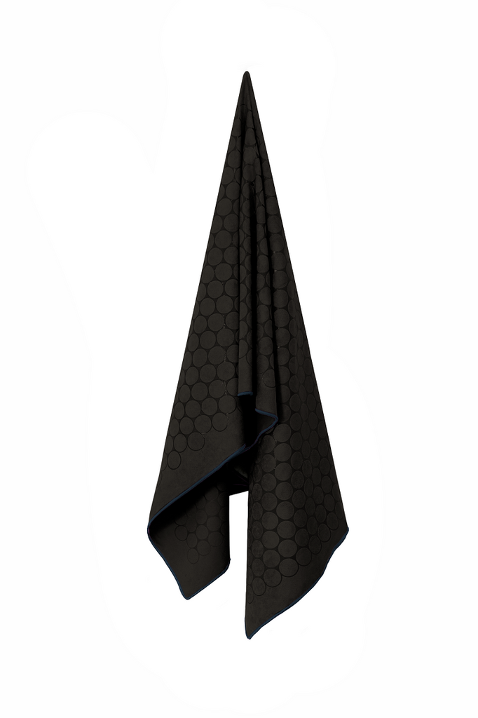 The GECKO TOUCH – Nightfall yoga towel features a simple yet elegant symmetrical circular pattern made of tactile silicone, offering a unique wet/dry grip. It comes with a sleek black graphite base with contrasting colored stitching and is made using an eco-friendly, dye-free process.