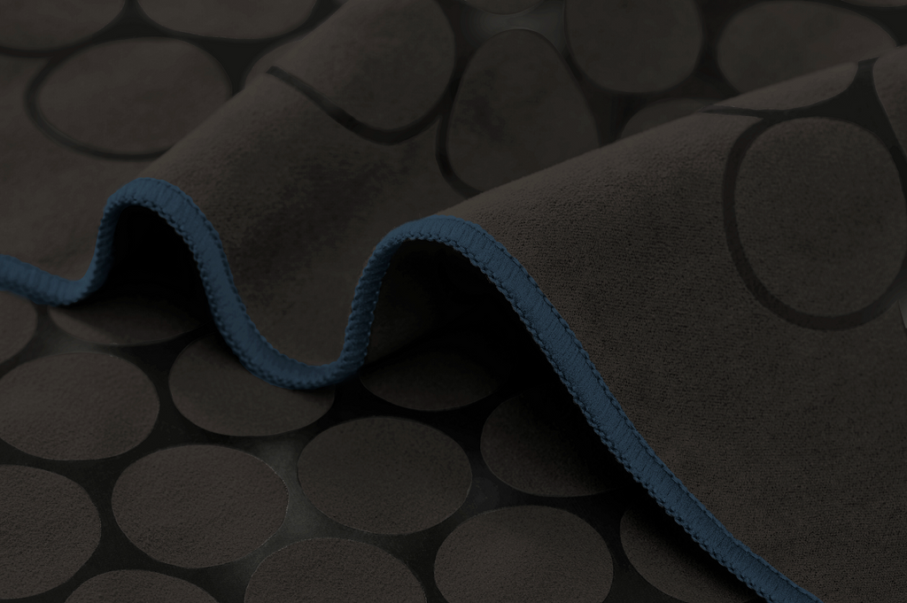 The GECKO TOUCH – Nightfall yoga towel features a simple yet elegant symmetrical circular pattern made of tactile silicone, offering a unique wet/dry grip. It comes with a sleek black graphite base with contrasting colored stitching and is made using an eco-friendly, dye-free process.
