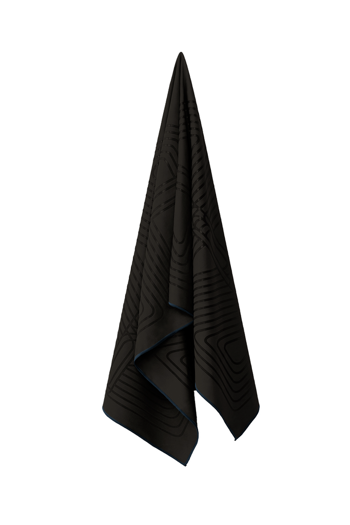 The GECKO WARRIOR – Nightfall yoga towel features a unique wet/dry grip Focus Alinement™ pattern made of tactile silicone, inspired by but not directly taken from ancient warrior cultures. It comes with a sleek black graphite base with contrasting colored stitching and is made using an eco-friendly, dye-free process.
